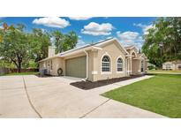 Side view of a home with a spacious driveway and attached garage at 101 Majestic Forest Run, Sanford, FL 32771
