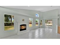 Bright living room with fireplace, many windows, and tile flooring at 101 Majestic Forest Run, Sanford, FL 32771
