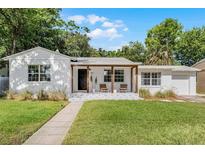 Charming single-story home with a covered porch, patterned patio, and beautiful landscaping at 1012 N Shine Ave, Orlando, FL 32803
