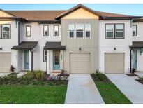 Inviting townhome exterior showcasing a blue front door, neutral color scheme, and well-maintained landscaping at 1067 Plantation Ln, Davenport, FL 33896