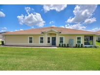 Charming single-story home featuring a well-manicured lawn, tile roof, and welcoming front entrance at 1082 Blackwolf Run Rd, Davenport, FL 33896