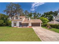 Charming two-story home features a front lawn, large trees and a two car garage at 120 W Minnehaha Ave, Clermont, FL 34711