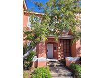 Charming two-story townhouse featuring a walkway, decorative shutters, and lush landscaping at 153 Pompano Beach Dr Dr, Kissimmee, FL 34746
