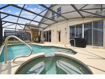 Screened-in pool and spa area featuring a built-in hot tub and relaxing patio furniture at 223 Cadiz Loop, Davenport, FL 33837