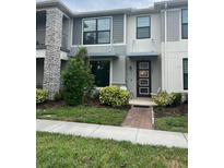 Stylish townhome with modern design, manicured landscaping, and inviting front entrance at 2702 Giardino Loop, Kissimmee, FL 34741