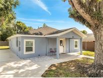 Charming blue home with a covered front porch, white trim, and a well-maintained yard at 308 E Orange St, Kissimmee, FL 34744