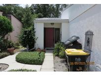 Charming home entrance with a red door and well-maintained landscaping at 386 San Jose Dr, Winter Haven, FL 33884