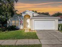 Charming single-story home featuring an attached two-car garage and well-manicured lawn at 421 Bailey Cir, Davenport, FL 33897
