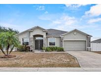 Charming single-story home with stone accents, neutral stucco, and a well-manicured lawn at 491 Majestic Gardens Blvd, Winter Haven, FL 33880