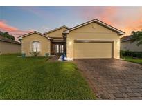 Charming single-story home featuring a well-maintained lawn and brick driveway at 5253 Pebble Beach Blvd, Winter Haven, FL 33884