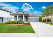 Charming single-story home featuring a well-manicured lawn, mature palm trees, and an attached two-car garage at 5876 Bar Ranch Rd, St Cloud, FL 34771
