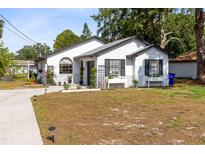 Charming white home with a well-maintained lawn, complemented by decorative plants and a welcoming entryway at 106 Edgewater Dr, St Cloud, FL 34769