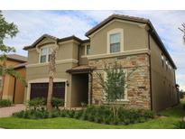 Stunning two-story home featuring a stone facade, well-maintained landscaping, and a two-car garage at 2147 Tripoli Ct, Kissimmee, FL 34747