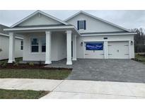 Charming single-Gathering home featuring a two-car garage, covered porch, and neutral-colored exterior at 3048 Prelude Ln, Kissimmee, FL 34746