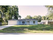Charming single-story home with a well-manicured lawn, attached two car garage and a light blue exterior at 3661 Se 131St Pl, Belleview, FL 34420