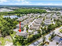An aerial view of a condo complex with a pond, landscaping, parking, and community amenities at 4551 Jonafree Ln # 103, Kissimmee, FL 34746