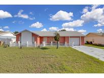 Charming single-story home featuring a well-manicured lawn, concrete driveway, and attached garage at 572 Floral Dr, Kissimmee, FL 34743