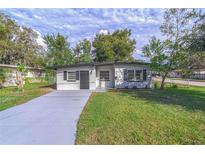 Charming single-story home with fresh gray paint and manicured front lawn at 673 E Church Ave, Longwood, FL 32750