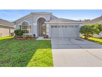 Charming single-story home featuring a manicured lawn and an attached two-car garage at 707 Stonewyk Way, Kissimmee, FL 34744