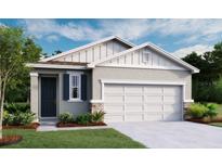 Charming single-story home featuring a two-car garage, craftsman-style details, and a welcoming front yard at 749 Lake Dell Ave, Dundee, FL 33838