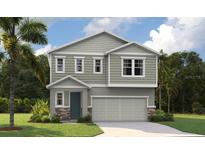 Charming two-story home with a gray exterior, a front-entry two-car garage, and lush, green landscaping at 753 Lake Dell Ave, Dundee, FL 33838