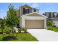 Charming two-story home features a two-car garage and manicured front lawn at 815 Lake Dell Rd, Dundee, FL 33838