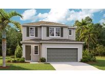 Charming two-story home featuring a neutral color scheme, attached garage, and well-manicured lawn at 819 Lake Dell Rd, Dundee, FL 33838