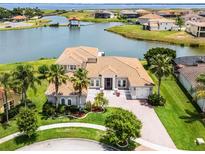 Stunning waterfront home with a well-manicured lawn, tile roof, and lush landscaping, perfect for serene living at 1110 Terralago Way, Kissimmee, FL 34746