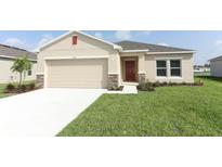 Charming single-story home featuring a neutral color palette, two-car garage, and well-manicured lawn at 165 Citrine Loop, Kissimmee, FL 34758