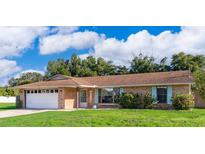 Charming single-story home with a brick facade, well-manicured lawn, and vibrant blue shutters at 1730 Carolyn Ct, St Cloud, FL 34769
