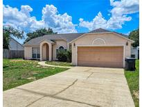 Charming single-story home featuring a well-maintained lawn and attached two-car garage at 215 Grovepark Dr, Davenport, FL 33837
