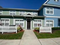 Charming townhome with a well-manicured lawn and a welcoming white picket fence at 2203 San Vittorino Cir # 103, Kissimmee, FL 34741