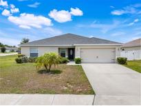 Charming single-story home features a well-manicured lawn and attached two car garage at 233 E Cattail, Lake Alfred, FL 33850