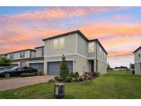 Charming two-story townhome featuring an attached garage, manicured lawn, and a welcoming entrance at 2462 Sweet Viburnum Way, Ocoee, FL 34761
