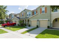 Inviting townhouse exterior with a two-car garage and well-maintained landscaping and beautiful shutters at 3181 Tocoa Cir, Kissimmee, FL 34746