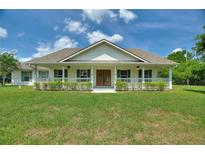 Charming single-story home with a welcoming front porch, green shutters, and well-manicured landscaping at 3440 La Salle Ave, St Cloud, FL 34772