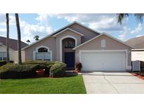 Charming single-Gathering home with a well-maintained lawn, blue door, and two-car garage at 4707 Pershoie Ln, Kissimmee, FL 34746