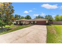 Charming single-story home featuring a well-maintained lawn and a spacious driveway leading to the garage at 4824 Reginald Rd, Orlando, FL 32829