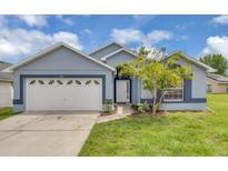 Charming single-story home with a well-manicured lawn, a two-car garage, and appealing curb appeal at 664 Eagle Pointe S, Kissimmee, FL 34746