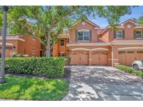 Beautiful two-story townhome with a brick paved driveway and a well-maintained landscape at 6970 Piazza St, Orlando, FL 32819