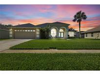 Charming single-Gathering home with manicured lawn, two-car garage, and beautiful arched entryway at 952 Chamberlin Trl, St Cloud, FL 34772