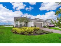 Charming single-Gathering home boasts a well-manicured lawn, lush landscaping, and an attached two-car garage at 10364 Shive Island Ct, Orlando, FL 32827