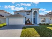 Charming two-story home with a well-manicured lawn, attached garage, and inviting front entrance at 12303 Bohannon Blvd, Orlando, FL 32824