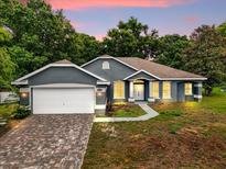 Charming single-story home featuring a brick driveway, well-maintained lawn, and inviting curb appeal at 14610 Wishing Wind Way, Clermont, FL 34711