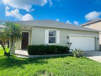 Charming single-story home featuring a well-manicured lawn and an attached two-car garage at 2728 Portchester Ct, Kissimmee, FL 34744