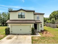 Two-story home featuring an attached two-car garage, neutral color scheme and well-maintained landscaping at 320 Southern Winds Blvd, Deland, FL 32720