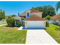 Inviting two-story home with a well-manicured lawn and attached two-car garage at 3203 Herons Point Cir, Kissimmee, FL 34741