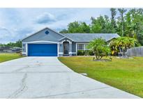 Charming single-story home featuring a well-manicured lawn and a bright blue two-car garage door at 330 Chiquita Ct, Kissimmee, FL 34758