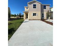 Inviting two-story home with a spacious concrete driveway and well-maintained lawn at 4855 Coral Castle Dr, Kissimmee, FL 34746