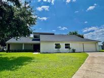 Charming single-story home boasts a lush lawn and attached two-car garage at 7200 Green Pine Ct, Orlando, FL 32819